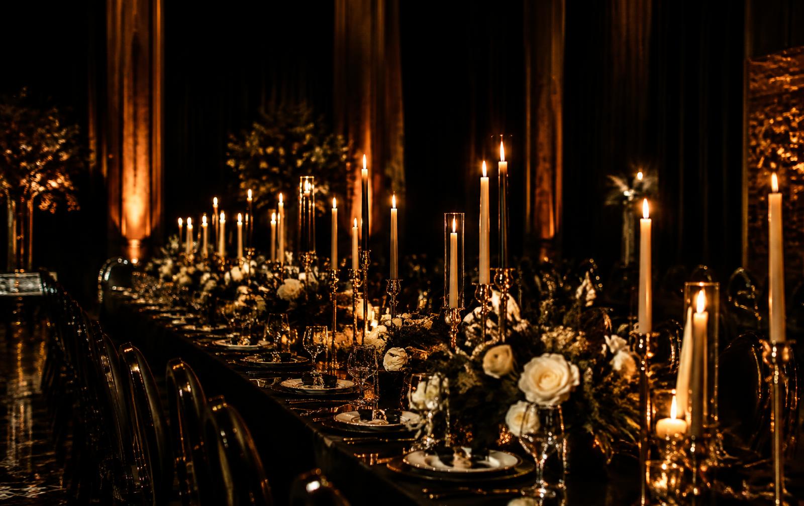 Candlelit banquet table styled in black and gold
